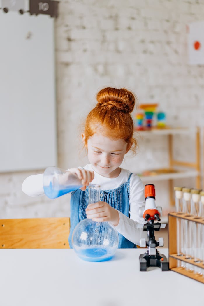 A young girl enthusiastically conducting a science experiment in a classroom setting, using beakers and test tubes.