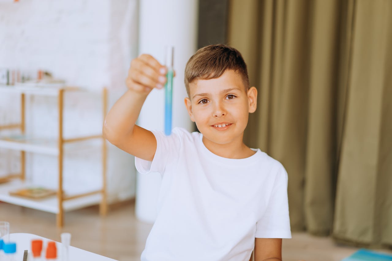 Smiling child holding test tube during a science experiment at home.